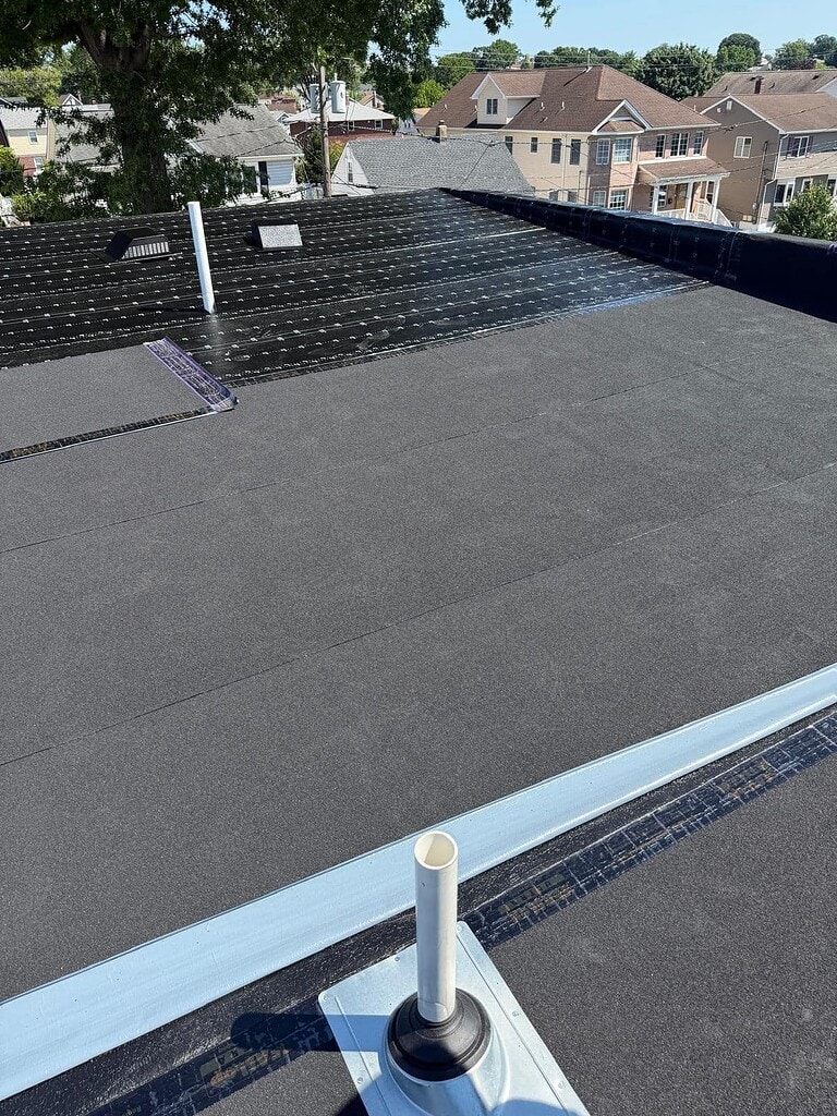 New flat roof with metal edge and new pipe flashing on a New Jersey home
