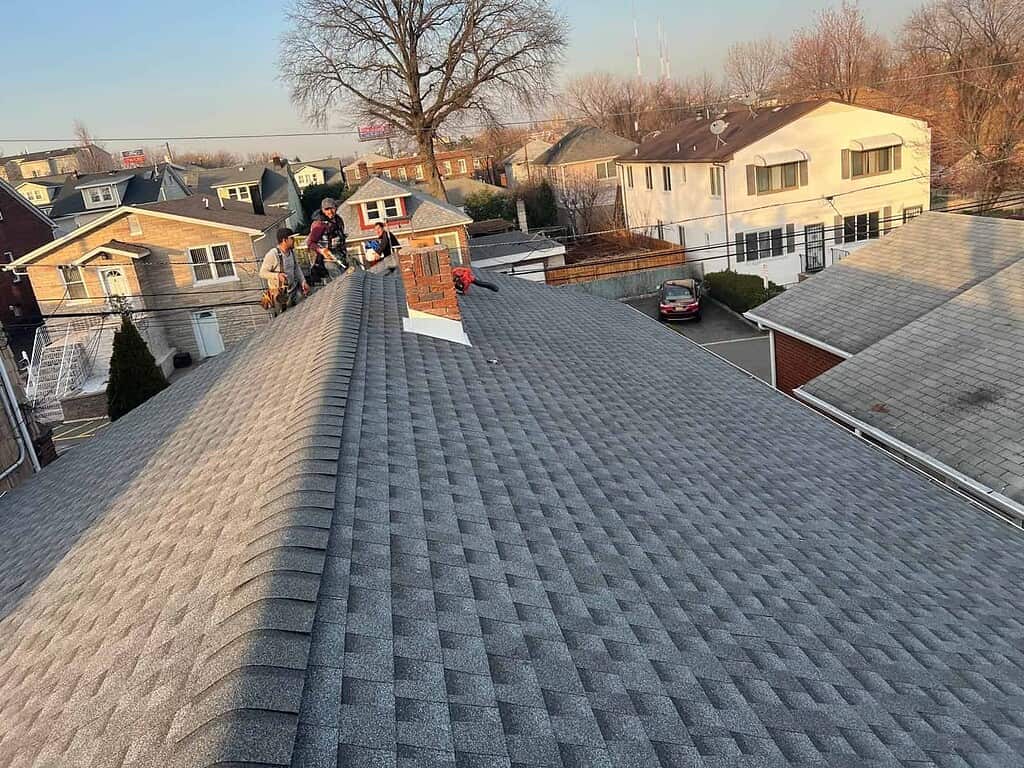 Better Build Construction crew finishing a new asphalt shingle roof around a brick chimney in New Jersey