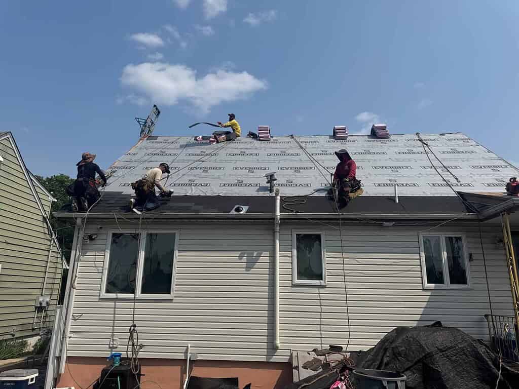 Better Build Construction roofers installing underlayment on a New Jersey house before new shingles