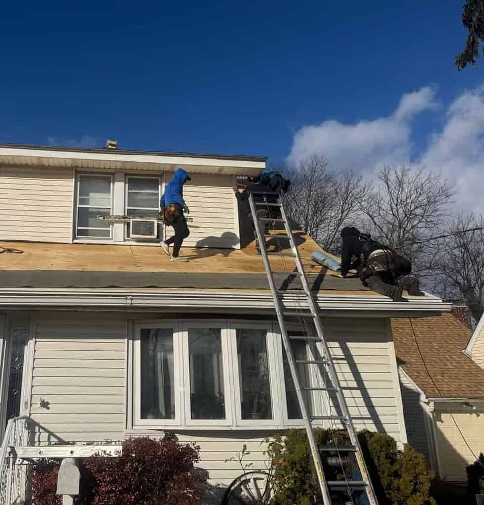 Better Build Construction roofers working on new roof decking at the lower edge of a New Jersey home