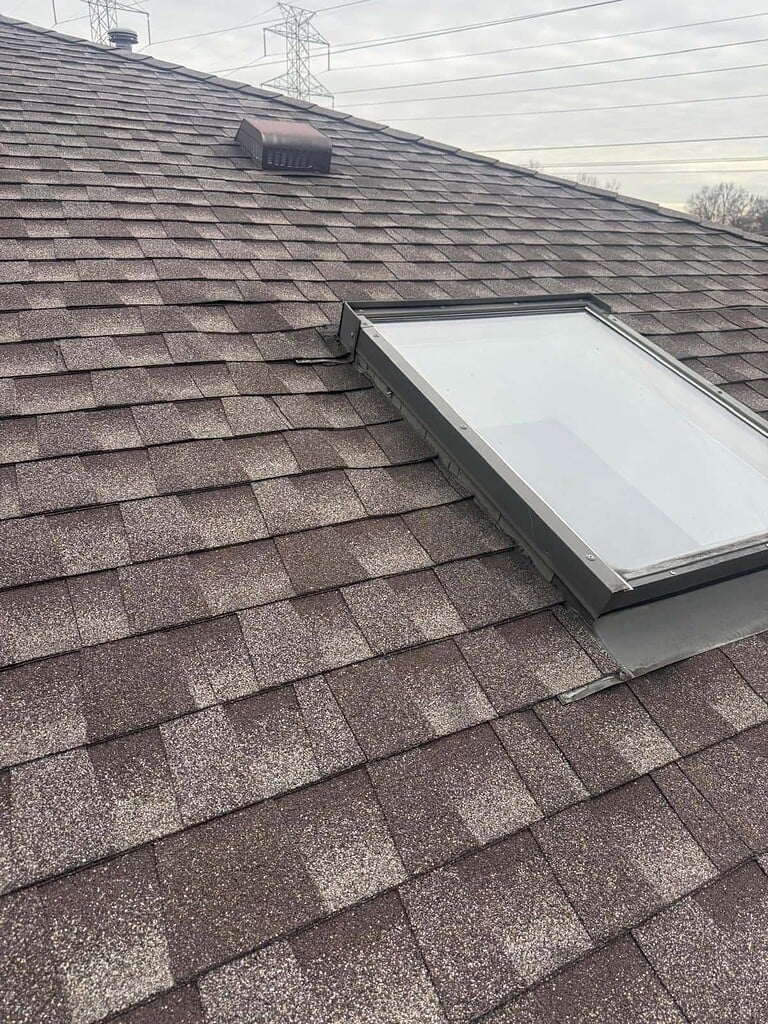 Skylight flashed into a new brown asphalt shingle roof on a New Jersey home
